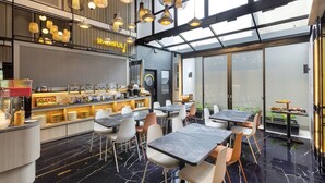 A modern cafe with a bar area, seating, and a view through large windows.
