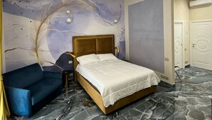 Ein modernes Schlafzimmer mit einem Bett, einem blauen Sessel und einem Marmorboden.