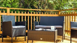 Un espacio al aire libre con mobiliario de mimbre y una cerca de madera.