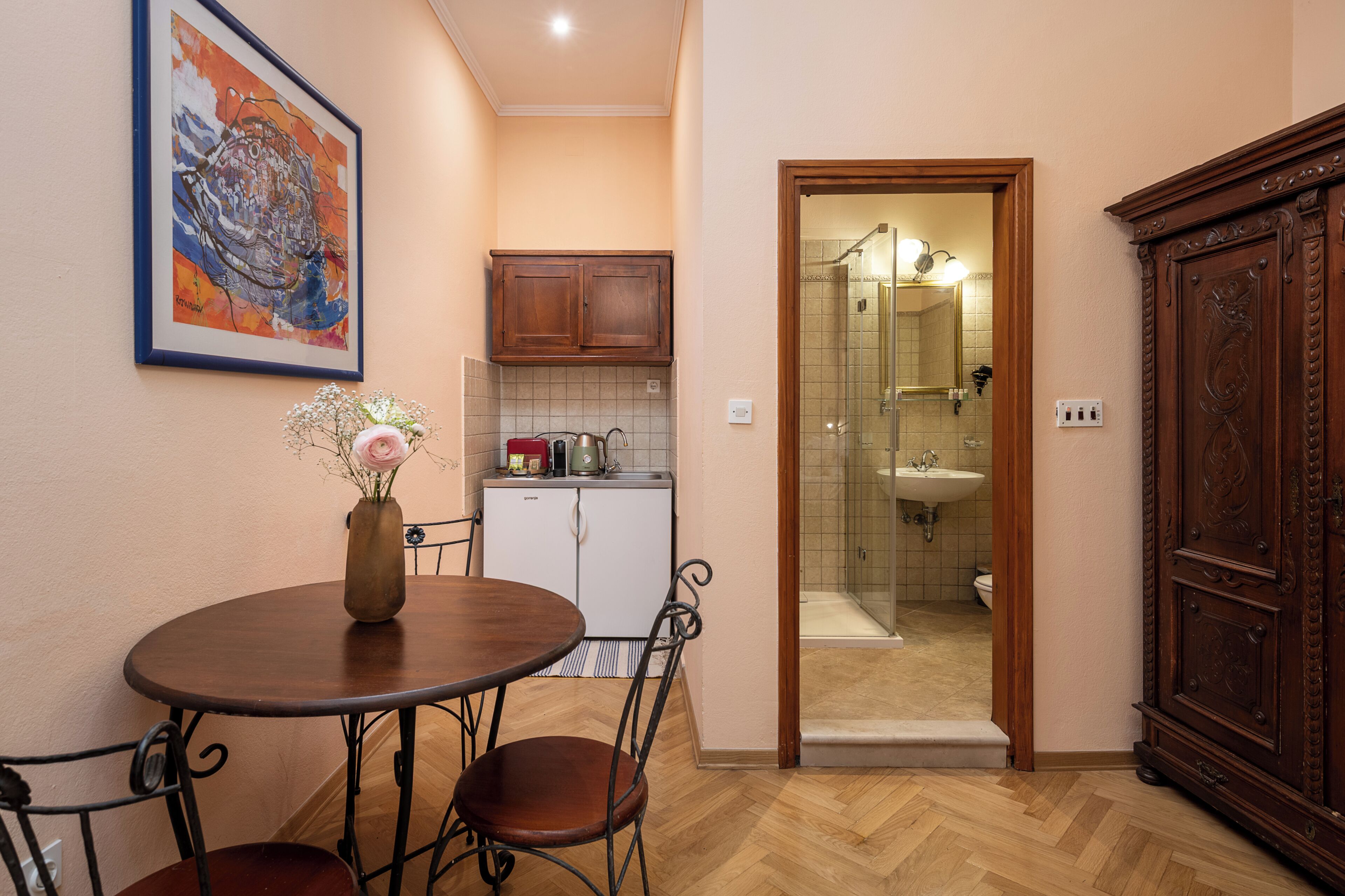 A compact kitchen with a refrigerator, cabinets, and a sink.