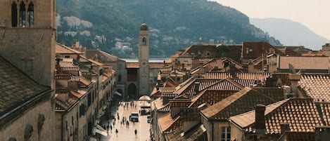 Una plaza histórica con edificios de piedra, una torre destacada y un campanario.