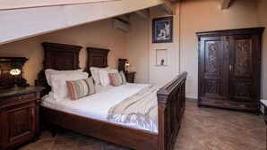 A bedroom with a wooden bed, nightstands, a wardrobe, and a framed picture on the wall. - Antaeus Old Town Residence (Dubrovnik)