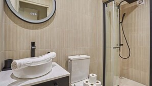 Un baño moderno con inodoro, toalla y ducha.