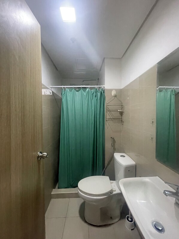 A bathroom with a toilet, sink, and shower curtain.