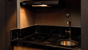 A compact kitchen with a microwave, stove, and wooden cabinetry. - NSC 1085 (Rio de Janeiro)