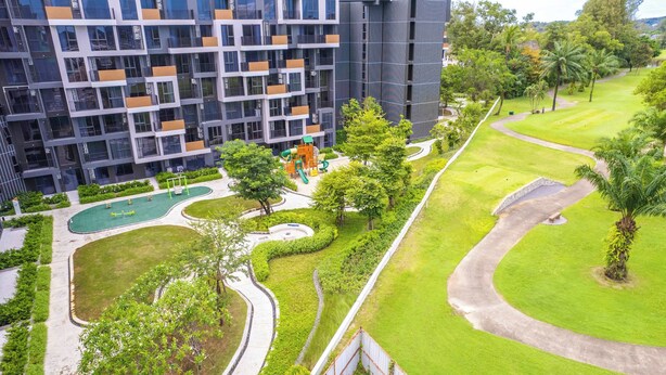 Un immeuble d’appartements moderne doté d’un terrain de jeux, d’espaces verts et d’un parcours de golf.