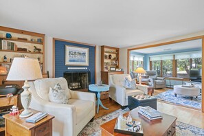 A living room with a fireplace, sofas, a coffee table, and a television.
