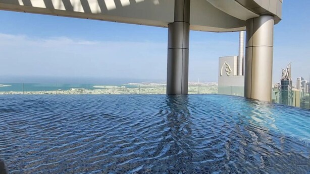 Una piscina infinita con vistas al horizonte de la ciudad y al mar.