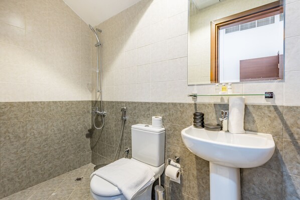 Un baño moderno con ducha, inodoro y lavamanos.