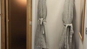 A bathroom with a wooden door, a towel rack with two towels, and a framed picture on the wall. - Wellness-Loft: sauna, jacuzzi&  cinema. Centrally located near the station (Bodegraven)
