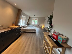 Une chambre moderne avec un grand lit, une table de chevet, un bureau et une fenêtre.