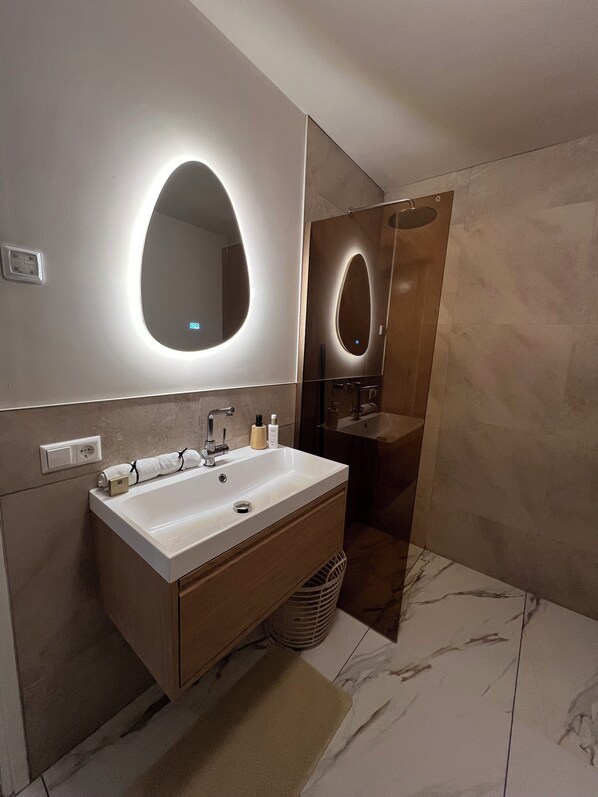 Une salle de bain moderne avec un grand lavabo, un miroir et un porte-serviettes.