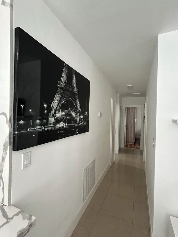 A hallway with a large black and white photograph of the Eiffel Tower on the wall.