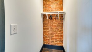 A narrow hallway with a brick wall and a white ceiling. - Steps to Shops & Dining: Downtown Marshall Studio! (Marshall)
