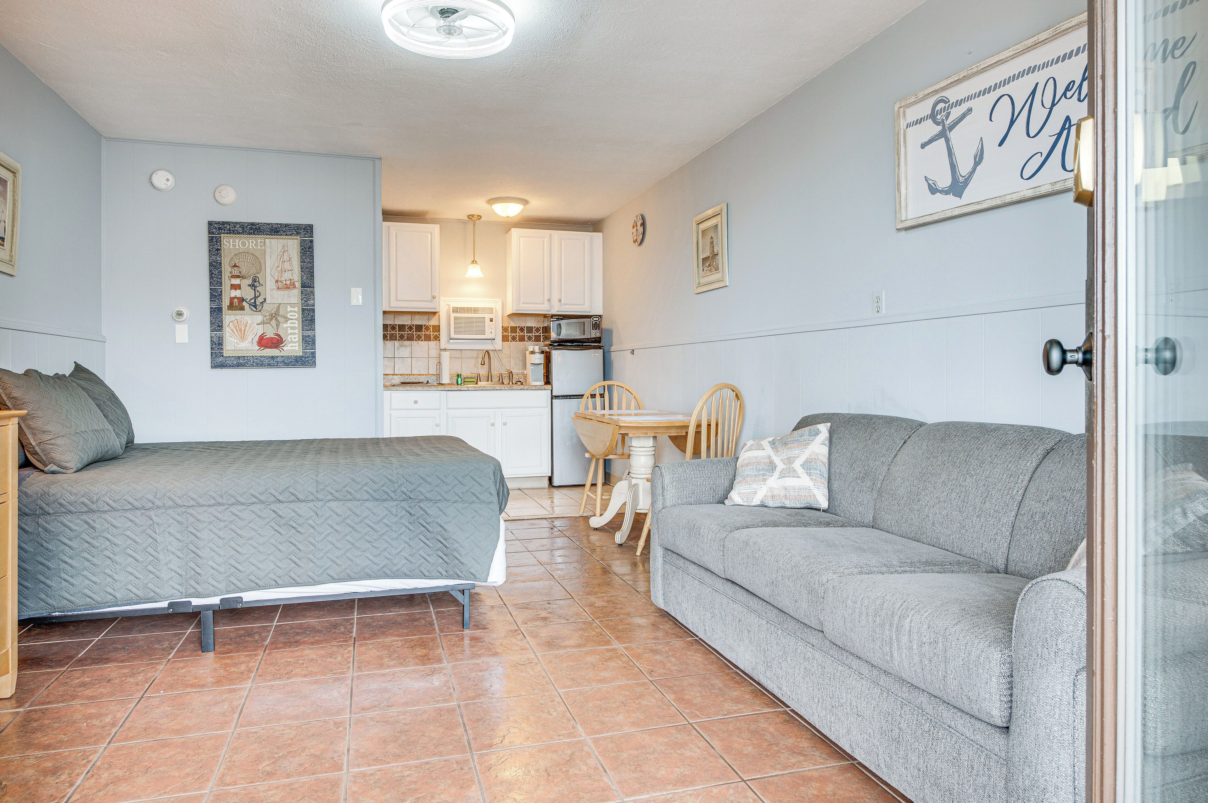 Une pièce de taille modeste comprenant un lit, un canapé, une table à manger et un coin cuisine.