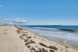 Een strand met een zandstrand en golven.