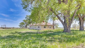 A house with a large tree in front, surrounded by grassy fields. - Secluded Stay: Serene Farmhouse in Trinidad! (Trinidad)