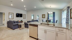 A spacious living area with a kitchen, a dining area, and a seating area with sofas.
