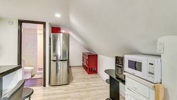 A compact kitchen with a refrigerator, microwave, and a small dining area.