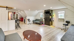 A spacious living area with a high ceiling, a dining area, and a kitchenette. - Walk to Main St Stroudsburg! Pocono Townhome (Stroudsburg)