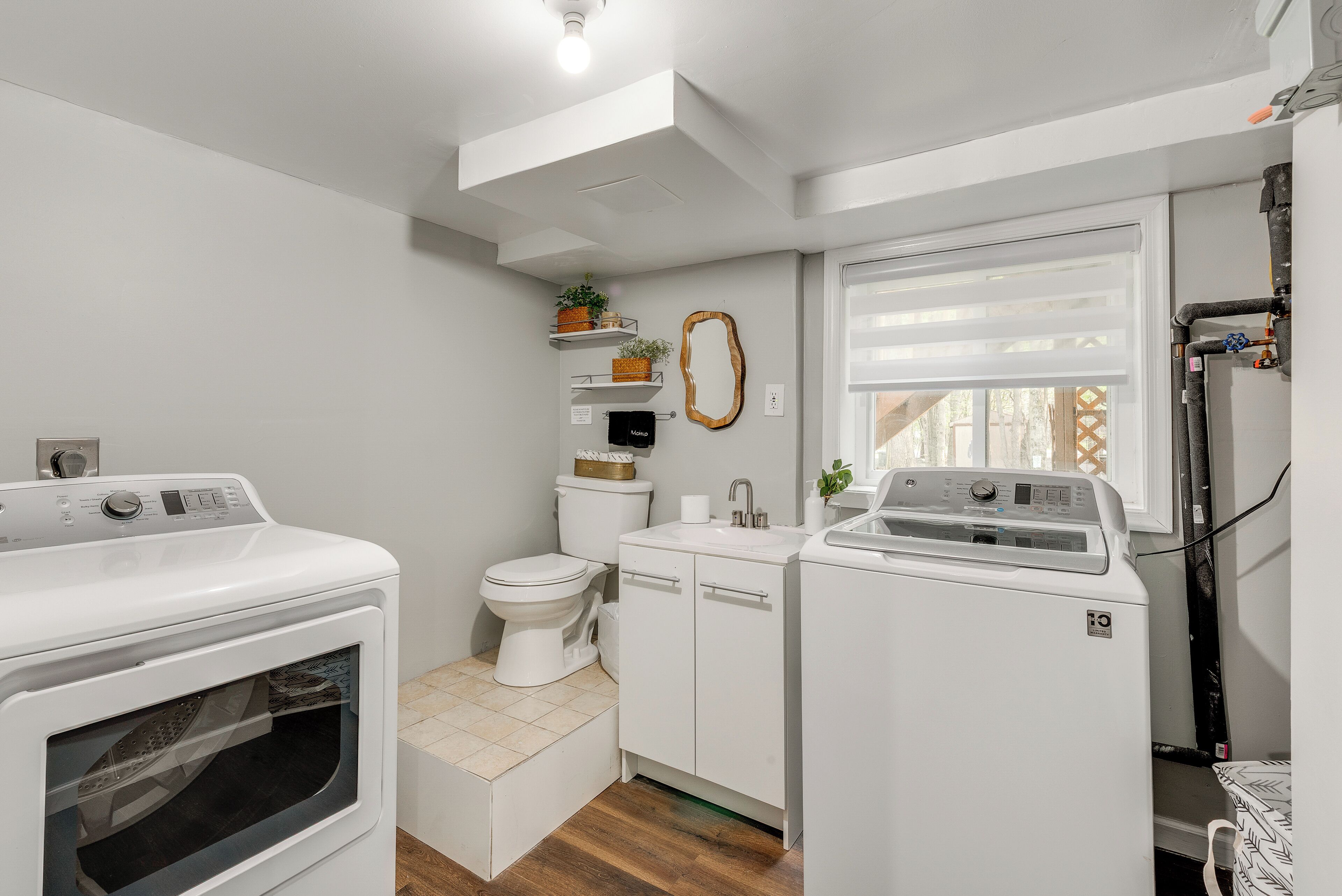 A compact laundry room with a washing machine, dryer, and a toilet.