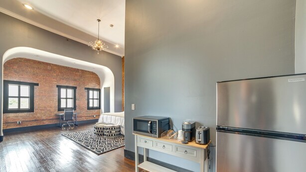 A modern kitchen with a stainless steel refrigerator, a microwave, and a coffee maker on a wooden countertop. - Historic Downtown Location: Marshall Studio Escape (Marshall)