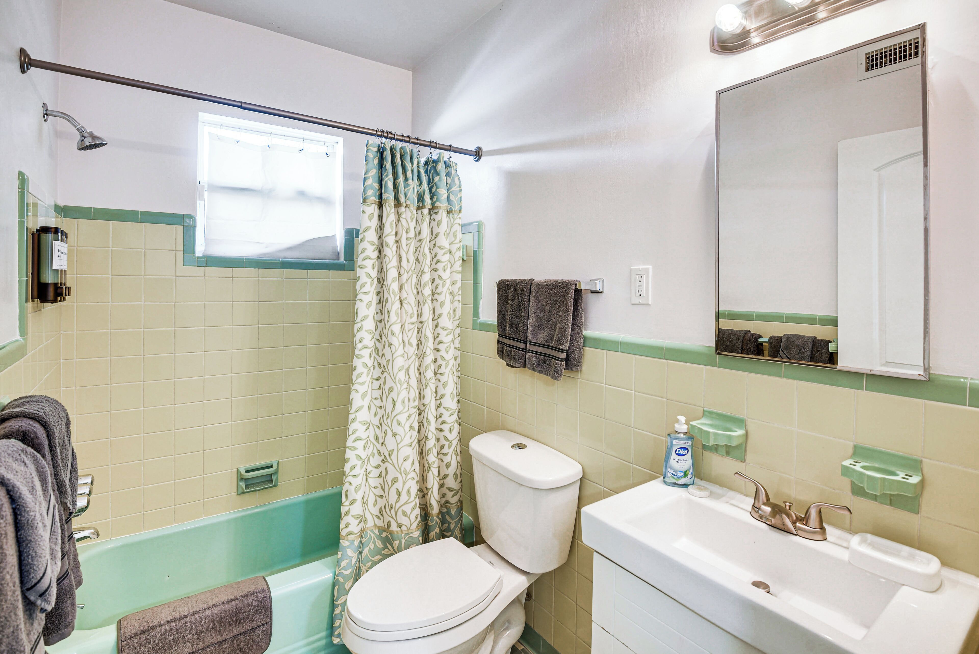 A bathroom with a bathtub, toilet, sink, and a shower curtain.