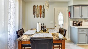 A dining area with a marble table, leather chairs, and a ceiling fan.