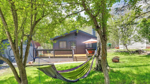 A house with a deck, a hammock, and a grassy yard.
