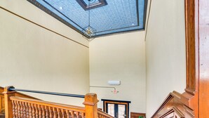 Una gran escalera con barandillas ornamentales y un techo alto con diseños elaborados.