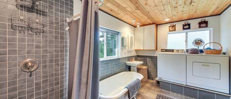 A bathroom with a bathtub, shower, and tiled walls.