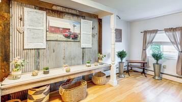 A rustic interior with a wooden bench, wicker baskets, and a welcome sign.