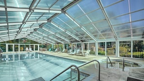 An indoor swimming pool with glass walls, a pool table, and lounge chairs. - Heated Pool & Hot Tub! Walk to Beach & Apache Pier (Myrtle Beach)