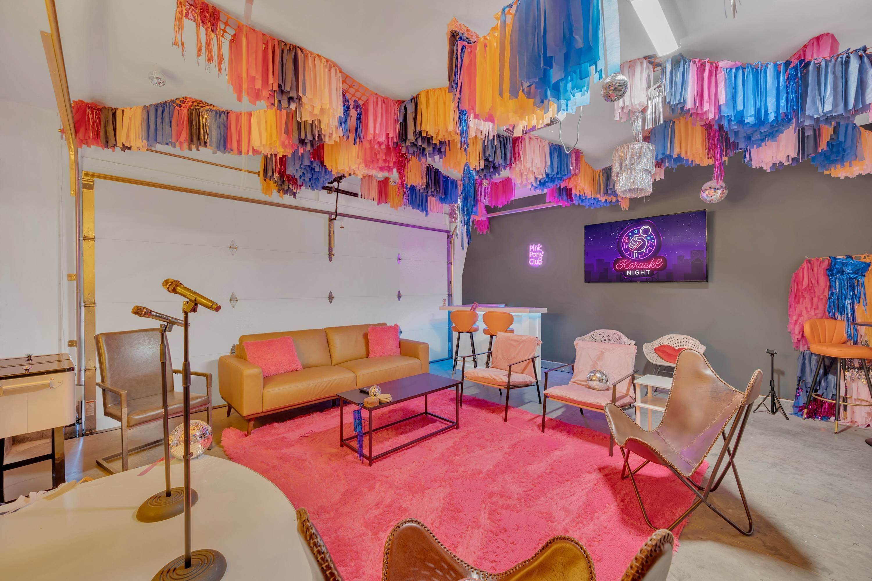 Una habitación con alfombra rosa, un sofá, una mesa de centro y un televisor mostrando 'Noche Flamenco Rosa'.