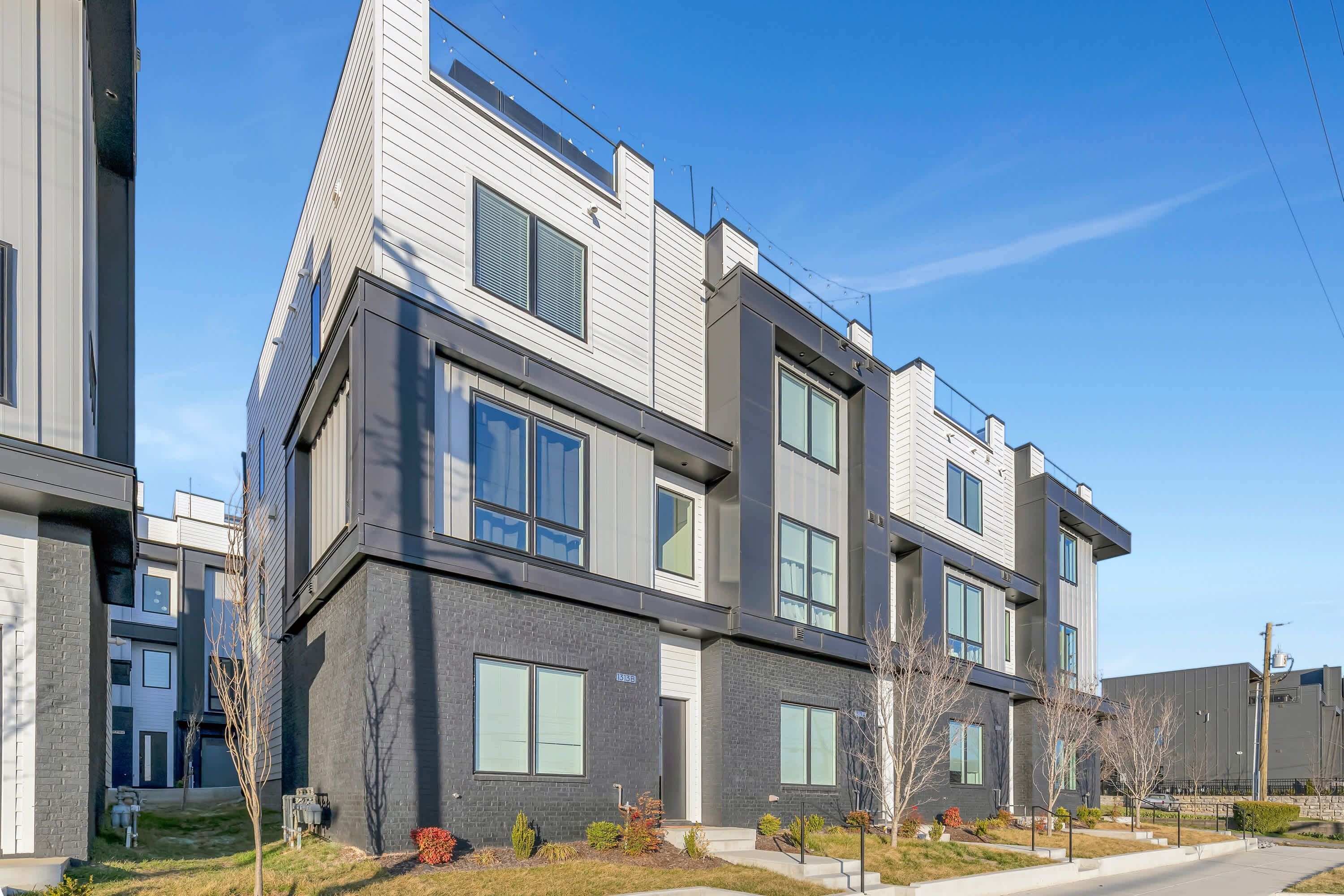 A modern multi-story residential building with large windows and a flat roof.