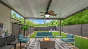 An outdoor patio with a fire pit, seating, and a ceiling fan. - Rooftop Large Backyard Fire Pit Near Downtown Nashville (Nashville)