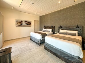 Quarto moderno com duas camas, cabeceiras de madeira, um quadro e piso de madeira.
