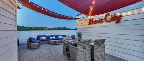 An outdoor patio area with wicker furniture, string lights, and a 'Movie City' sign.