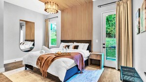A modern bedroom with a bed, bedside table, and a view of the outdoors. - 2 Hot Tubs Karaoke Game Room Downtown Nashville (Nashville)