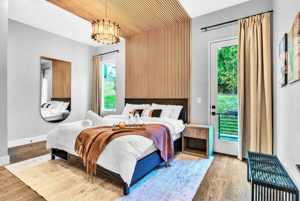Un dormitorio moderno con cama, mesita de noche y vistas al exterior.