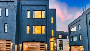 A modern two-story house with a garage, large windows, and a well-lit entrance. - Two Homes Hot Tub Rooftop Deck in Nashville (Nashville)