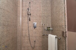 Een douche, handdoeken, zeep, toiletpapier