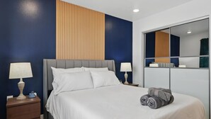 A neatly made bed with white linens, a grey headboard, and two bedside lamps. - Best of Knox Henderson - 1BD/1BA Style & Comfort (Dallas)