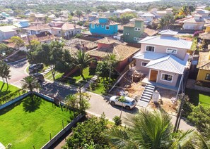 Una zona residencial con casas, un coche blanco y un césped verde.