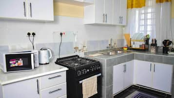 Appartement Classique, vue ville | Cuisine privée | Réfrigérateur, micro-ondes, batterie de cuisine, vaisselle et ustensiles