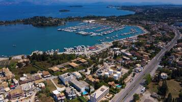 Vue aérienne d’une ville côtière avec un port de plaisance, des routes et des immeubles résidentiels.