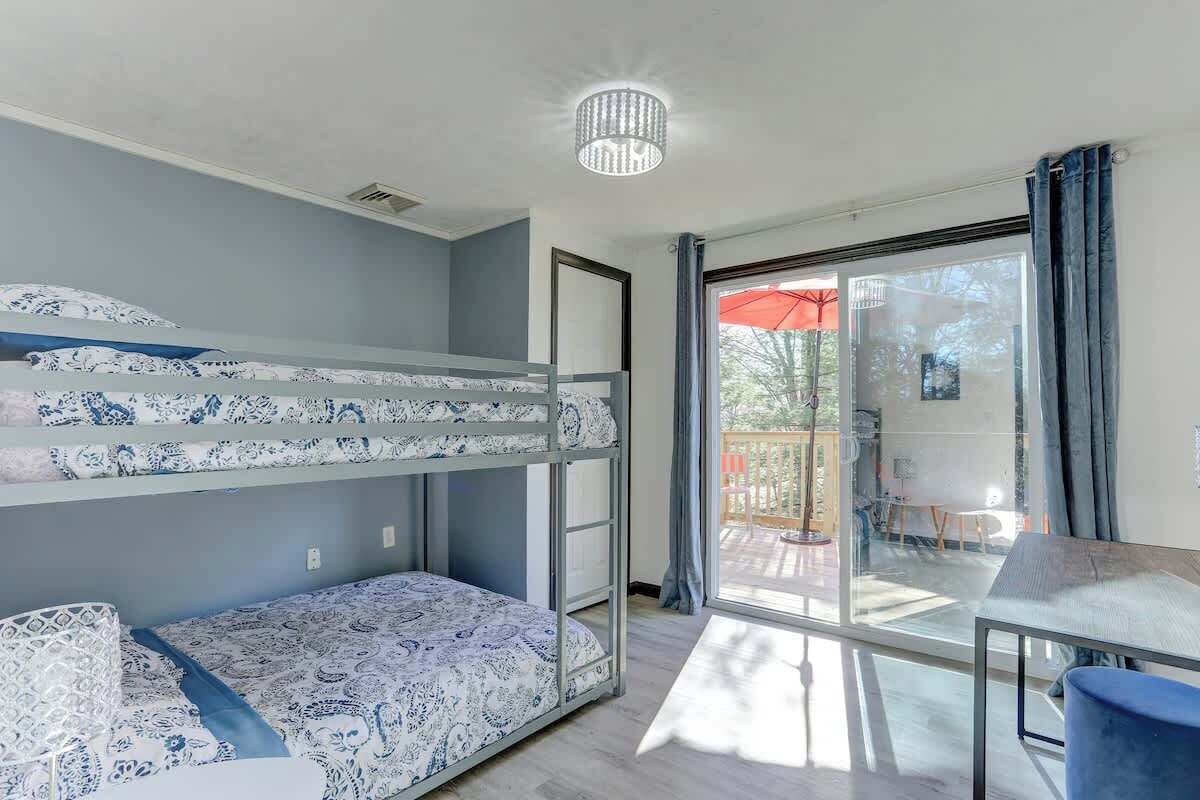 Una camera con un letto a castello e una porta in vetro che dà su uno spazio all'aperto.