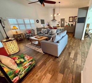 A modern living room with a sofa, coffee table, and a patterned ottoman.