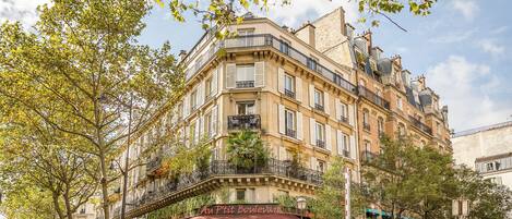 A corner building with a café named 'Au P'tit Boulevard' featuring a red awning.