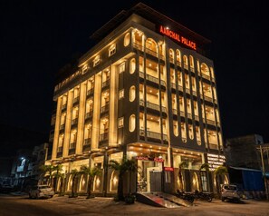 Un hotel de varios pisos con un letrero llamativo que dice 'AANCHAL PALACE'.